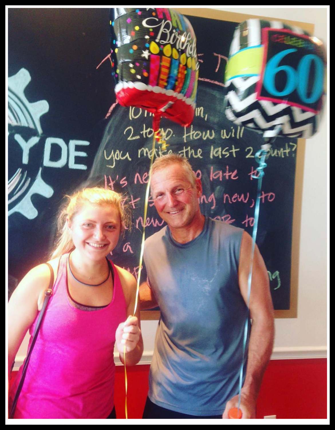 man and woman smiling for photo holding birthday balloons